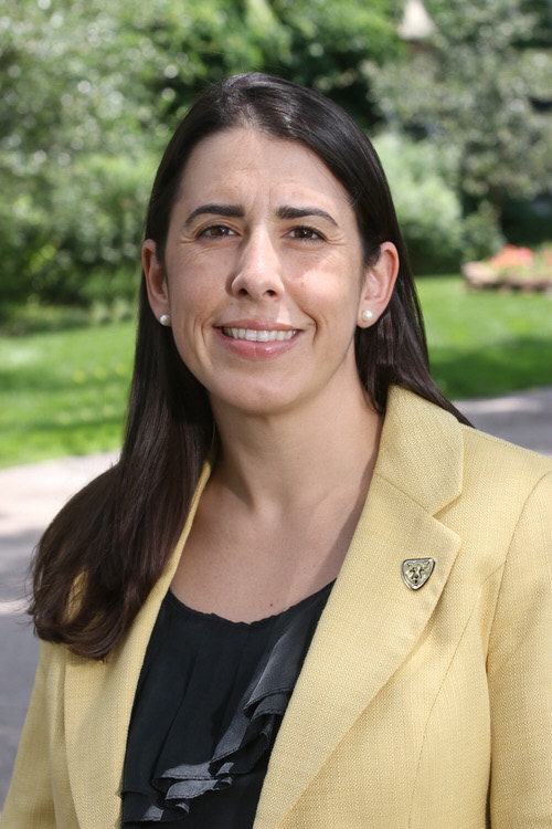 Portrait of Nicole Tugg wearing a yellow suit.