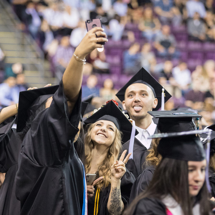 Graduates at Commencement posing for selfies